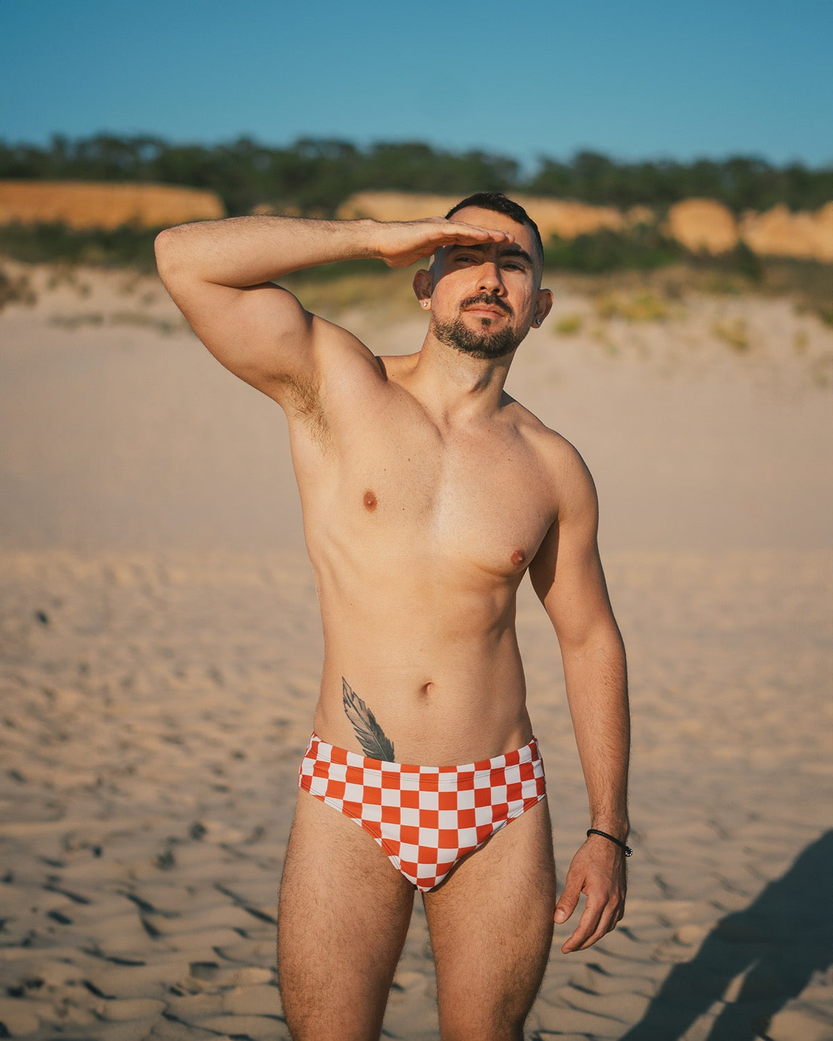 Mens Checkerboard Speedo style swim briefs, Burnt Orange checkered print swimming shorts, trendy gay swimwear by Alex Mac